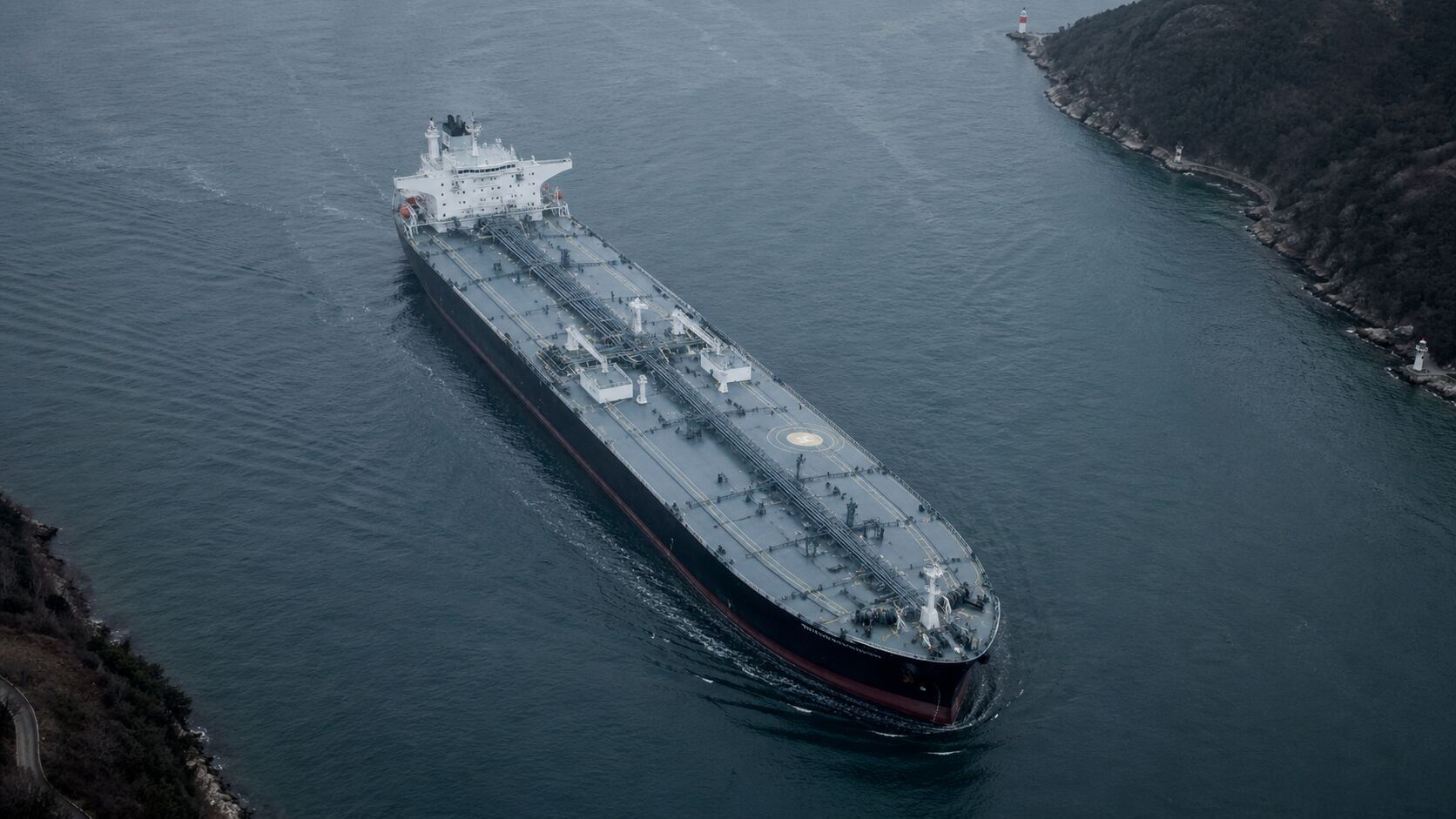 Oil tanker navigating a narrow strait, aerial view