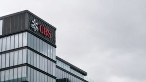 UBS headquarters building exterior with UBS gold price target revision — glass and steel corporate architecture under overcast sky