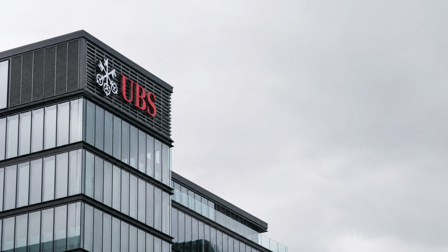 UBS headquarters building exterior with UBS gold price target revision — glass and steel corporate architecture under overcast sky