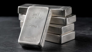 Stack of 999.0 fine silver bullion bars on a dark slate surface, illustrating physical silver as a long-term store of value