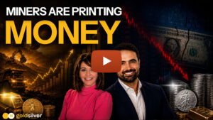 GoldSilver video thumbnail showing hosts Maggie Lake and Tavi Costa with the text "Miners Are Printing Money" against a backdrop of gold bars, silver coins, a mining excavator, and a falling stock chart