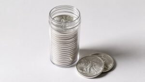A tube of American Silver Eagle coins with two rounds beside it — physical silver as a long-term store of value when the gold silver ratio signals undervaluation.