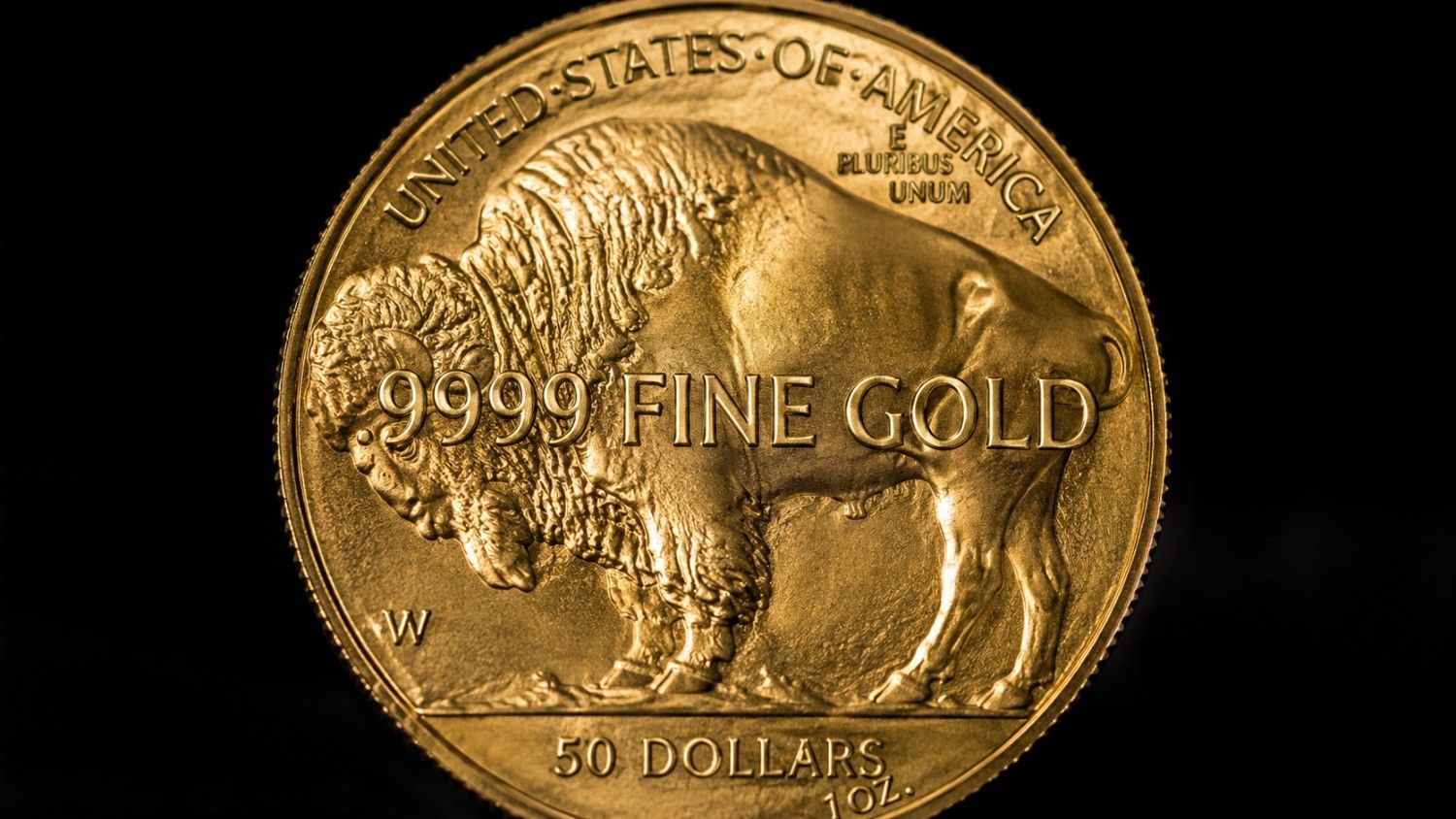 American Gold Buffalo coin reverse showing .9999 fine gold inscription, bison relief, and 50 dollars 1 oz denomination on black background