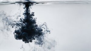 Ink drop spreading through still water, a visual metaphor for the Cantillon effect of uneven money distribution