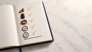 Notebook checklist with five checked-off icons — coins, an oil barrel, a copper coil, a gauge, and a clock — symbolizing gold options activity and other signals aligning before the Fed's decision
