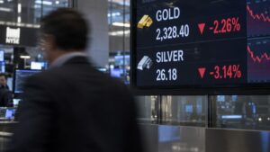 Digital trading floor ticker board showing gold and silver prices both down, reflecting today's gold silver ratio widening as the Trump-Xi summit opens.