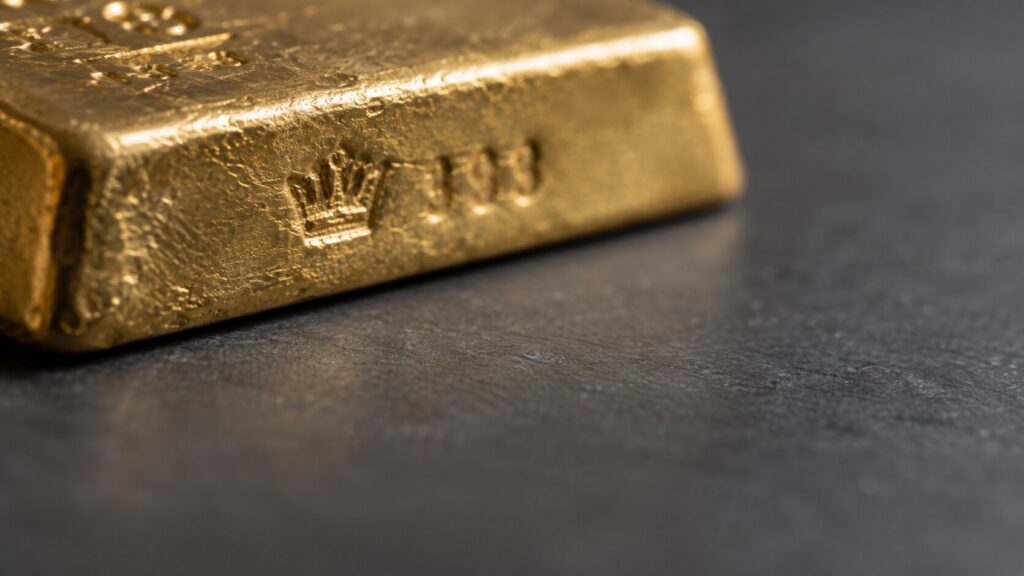 IRA-eligible gold: a macro view of a bullion bar stamped ".995 FINE GOLD," the IRS's minimum purity threshold for a Gold IRA.