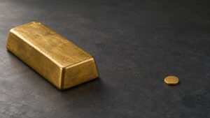 A large gold bar beside a single small gold coin, illustrating the size gap between a full redemption unit and a typical tokenized gold holding.
